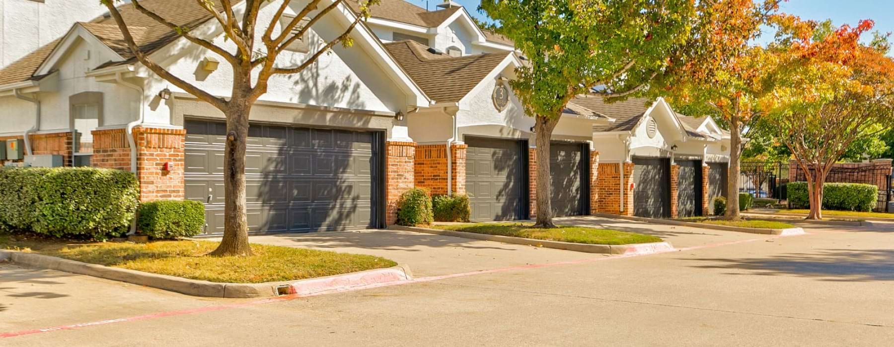 Private garages at our apartments for rent in Flower Mound, TX, featuring personal garages with parking spots outside.